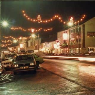 One of our photos is from the early eighties and it shows the then Chamber President, Pat Lynch, presiding over the official switching on of the lights. Fr Earley is doing the traditional blessing of the lights whilst a very young looking Cllr Christy Warnock and another former Chamber President, Pat Stenson, are also in the photo.