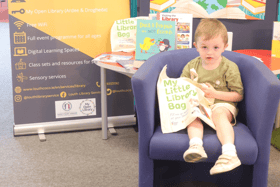 A young library user collecting his 'My Little Library Book Bag'