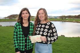 Aoife Bourke (left) and Lexi Ploc-Canning (right) pictured at Westport Quay with her letter from the bottle she threw into the Atlantic Ocean as an eight-year-old (Pic: The Mayo News)