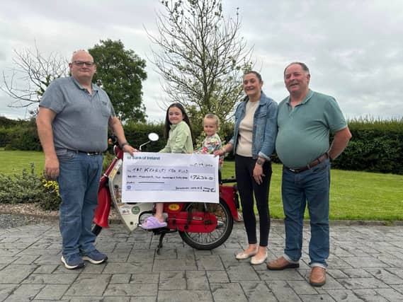 Darren Mulledy (left) and Mike Egan (right) presenting the cheque to Joan and her girls, Maddie and Allie
