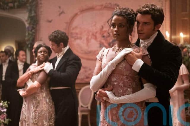 One image shows her character wearing an elaborate costume and having a seemingly romantic exchange with Lord Anthony Bridgerton, played by Jonathan Bailey, as the two prepare to dance.