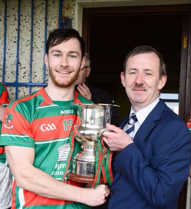 County Board Chairman Eamon Reilly presenting the JJ Duignan Cup to John Mulhern, the captain of the Wolfe Tones Mostrim senior hurlers after winning the county title yet again. Photo: Declan Gilmore