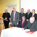 r Sean Casey, Vincent Fay, Niall Meagher (Project Manager), Derek Timlin, Michael Bane, Fr Tom Healy and Kevin Fay with Cllr Seamus Butler and Bishop Colm O'Reilly at the signing of the contract