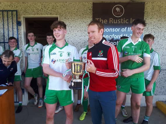 Killoe captain Niall Farrelly accepts the Kevin Hughes Cup from John Coyle