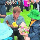 Prince Harry and Finn Doherty examine a historic photograph of their great-grandmothers meeting in 1927.