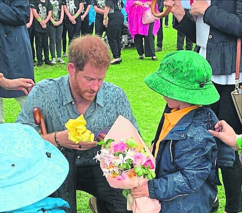 Prince Harry and Finn Doherty examine a historic photograph of their great-grandmothers meeting in 1927.