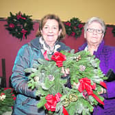 Rosaleen Briody and Ethel Ellis hold up a beautifully-crafted Christmas wreath at the Colmcille Christmas market, which took place recently. Photo: Michelle Ghee