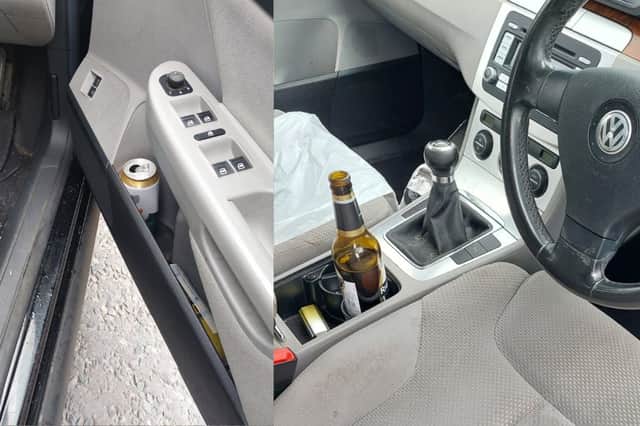 An open bottle of alcohol in the cup holder and an open can on the driver's side door
