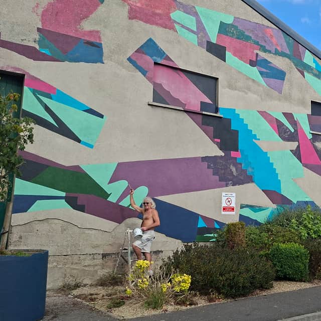 Brian Lyons carrying out restoration work on the Annaly Park mural
