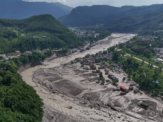 Damaged houses stand near the swollen, debris-choked banks of the Trishuli River after flash floods in Nepal’s Nuwakot district