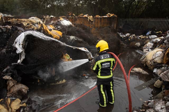 A fireman ensuring the blaze is fully extinguished