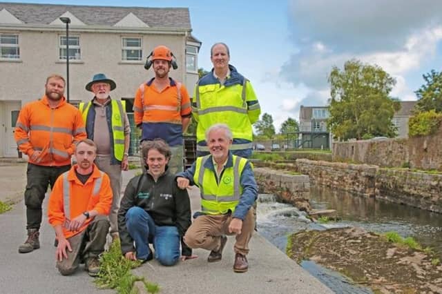 Above: Chandler McGuinness, Denis Glennon, Conor Murphy, Michael Reape, Liam Rabbitte, Adam Mulvihill and Michael Keenan. Left: Denis Glennon points through the arch opening towards the mill wheel. The stonework on the arch opening is hundreds of years old and was undoubtedly the result of highly skilled craftsmanship.