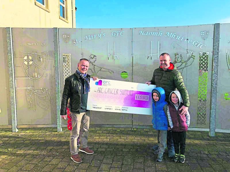 Secretary of St Mary's Eamon Scanlon and the brother of the late John O'Donoghue, Seamus, handing over the cheque to the Arc cancer support group. Also in the photo were Rian (6), Sam Scanlon (aged 4)