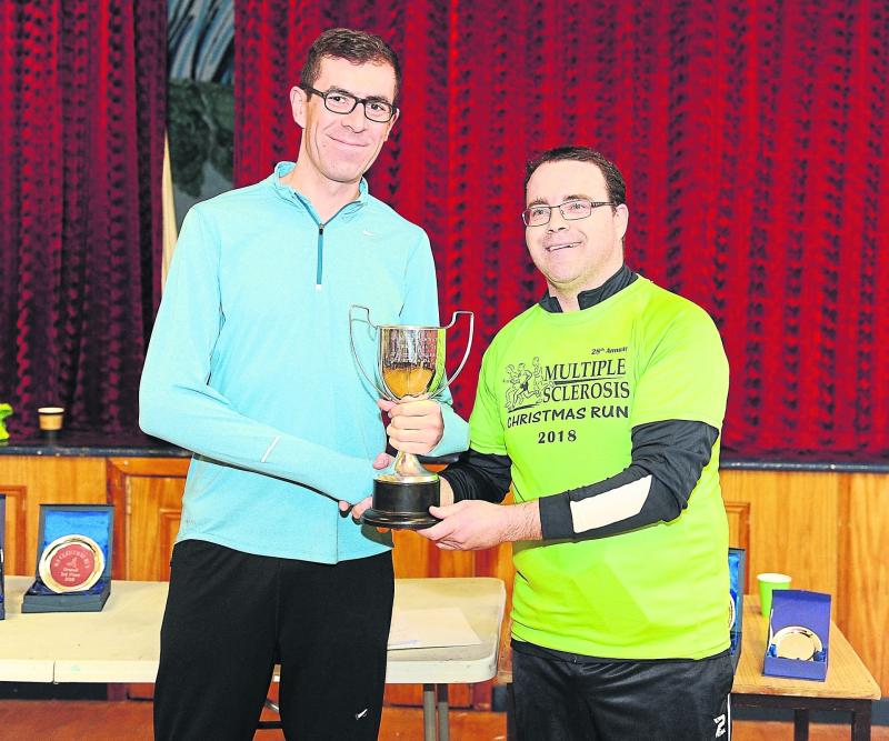Winner of the 28th annual Christmas Day Run from Newtowncashel to Lanesboro in aid of the Longford branch of Multiple Sclerosis Society in 2018, John Mulvihill is presented with the cup by Donal Casey