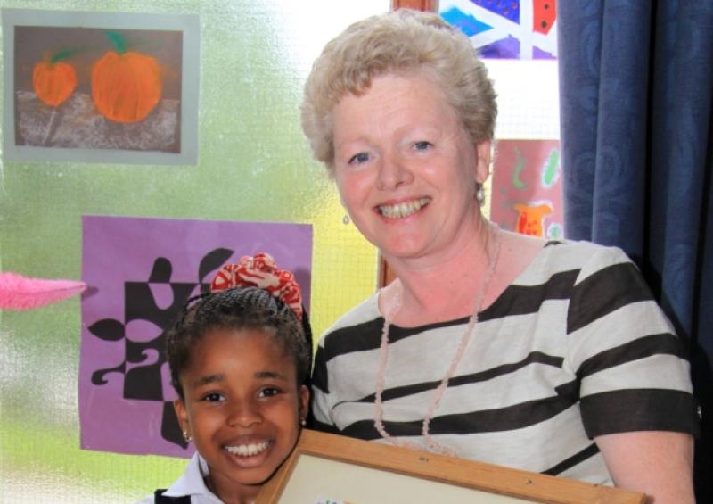 Juliet Ugboko from second class with outgoing principal Loretta Farrell at a prayer service in Mrs Farrell's honour. Photo: Michelle Ghee. www.gphotos.ie