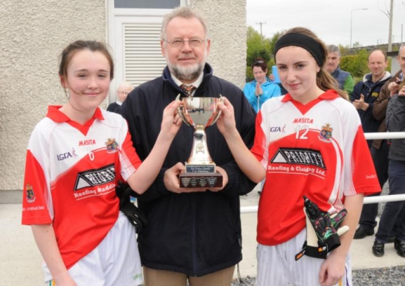 Mercy Ballymahon Secondary School joint captains Rebecca O'Kane and Petrina Carrigy are presented with the Leinster U-14 'B' Cup by Fionnbarra O'Drisceoil. Photo by Declan Gilmore