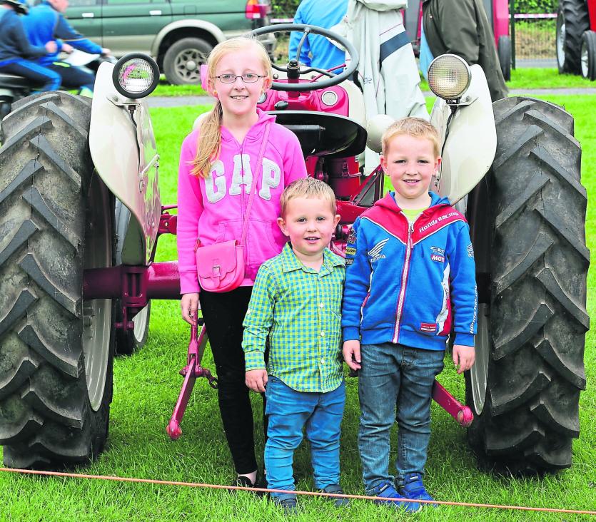 Shannon, Aaron and Kyle Coole admiring a vintage tractor